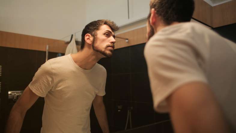 man looking at mirror